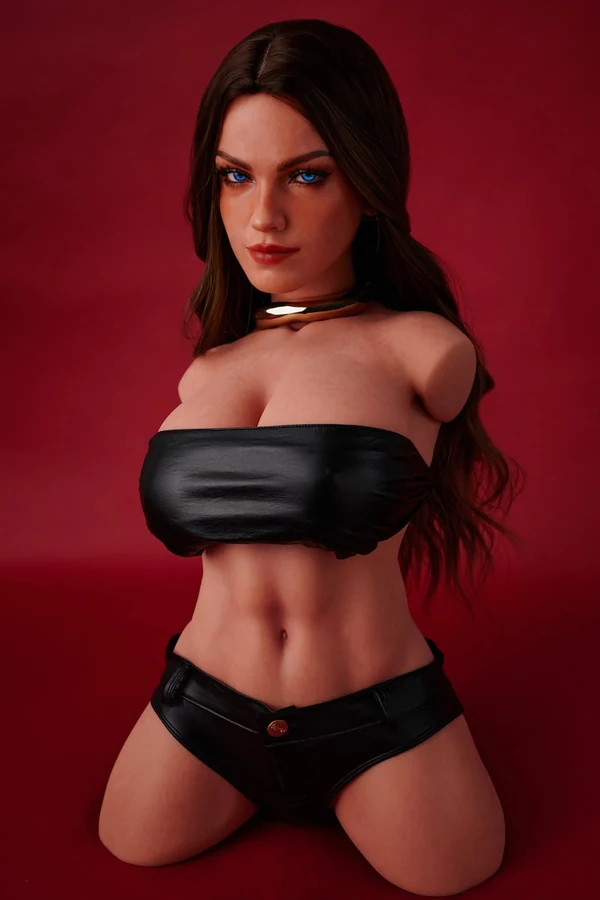 ULW 663# Emma: This front-view photo captures the doll's detailed torso featuring striking blue eyes and long wavy dark hair, wearing a black leather bandeau top that highlights her fair, smooth realistic skin and full curves against a red backdrop.