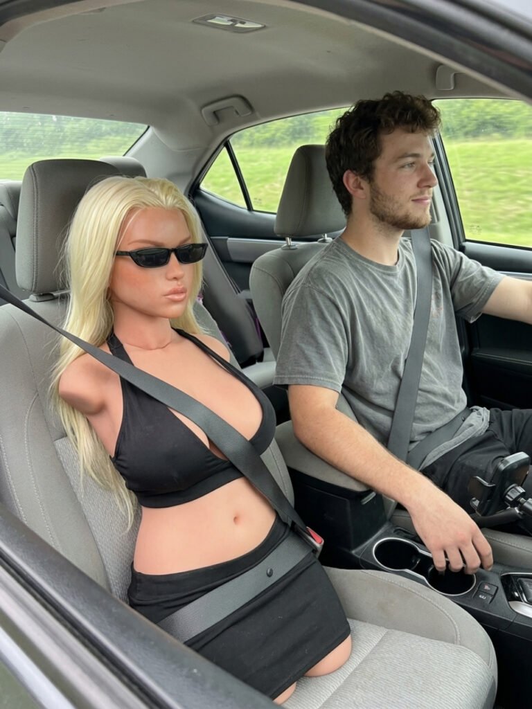 ULW Fiora torso with head wearing a black outfit and sunglasses in a car passenger seat