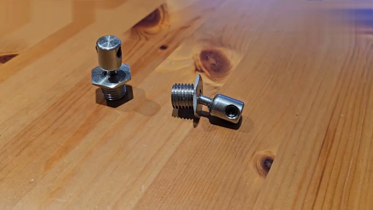 Two metal head-tilting connectors shown on a wooden surface